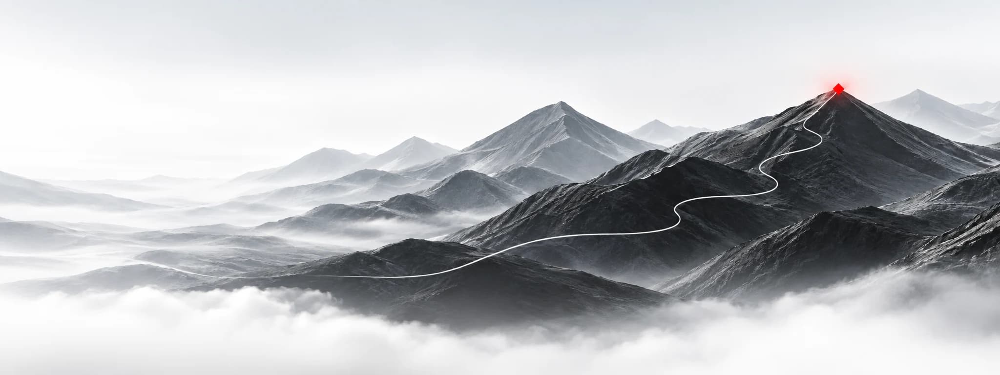 A winding trail climbing through a misty mountain range to a distant summit